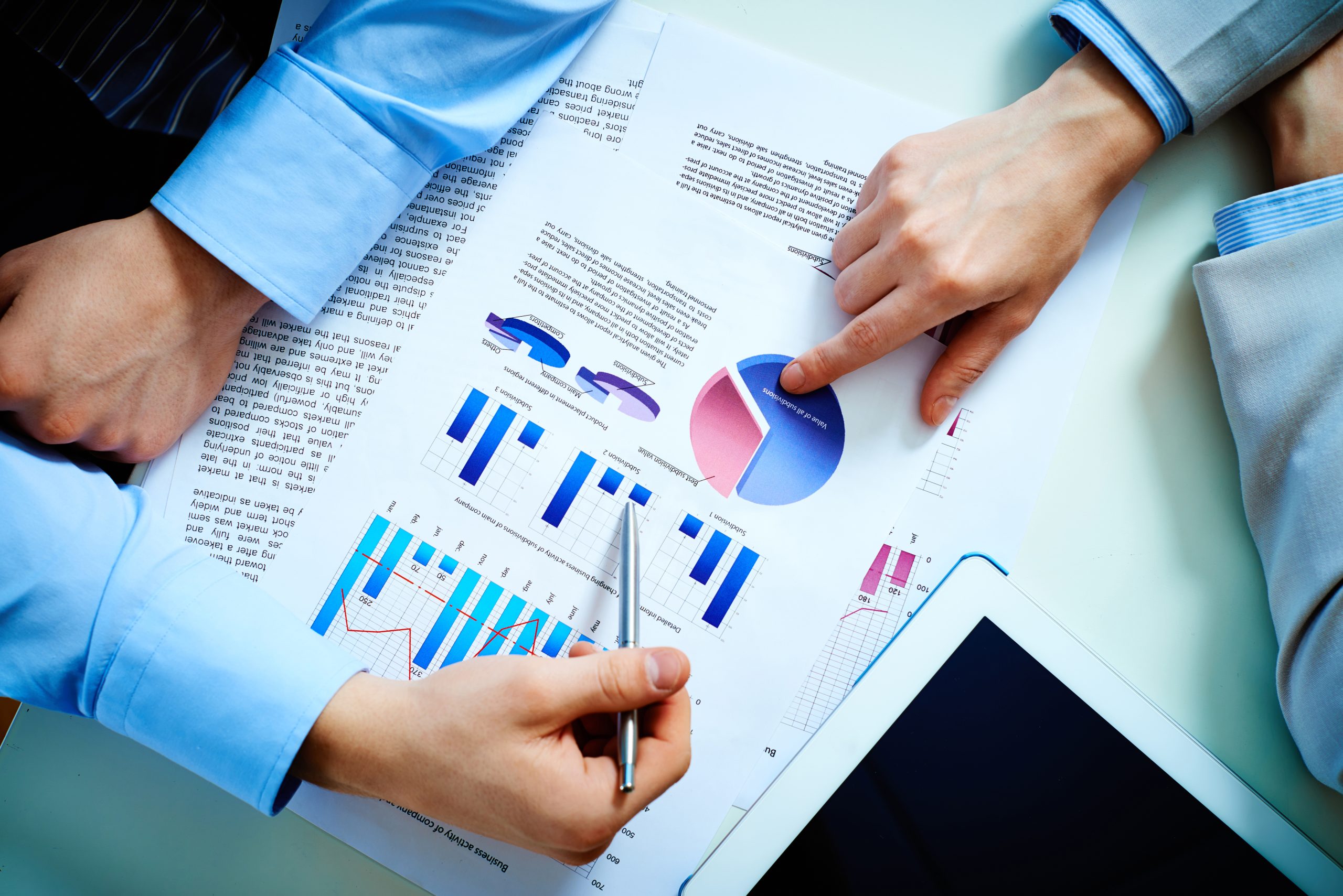 Close-up of female and male hands pointing at business document while discussing it